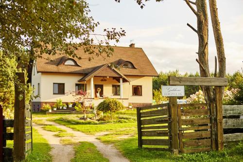 a house with a wooden gate and a fence at Galikowo in Płaska