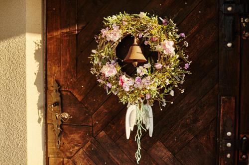 a wreath with a bell hanging on a door at Galikowo in Płaska
