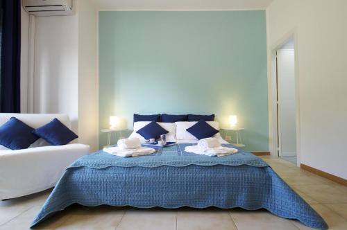 een slaapkamer met een bed met blauwe kussens en een bank bij Ferienwohnung für 1 Personen 2 Kinder ca 35 qm in Giardini Naxos, Sizilien Ostküste von Sizilien in Giardini Naxos