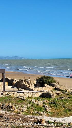 a beach with people walking on the sand and the ocean at Scala dei Turchi Apartment in Realmonte