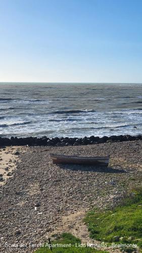 a boat sitting on a beach next to the ocean at Scala dei Turchi Apartment in Realmonte