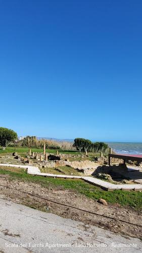 a picnic table on the beach next to the ocean at Scala dei Turchi Apartment in Realmonte