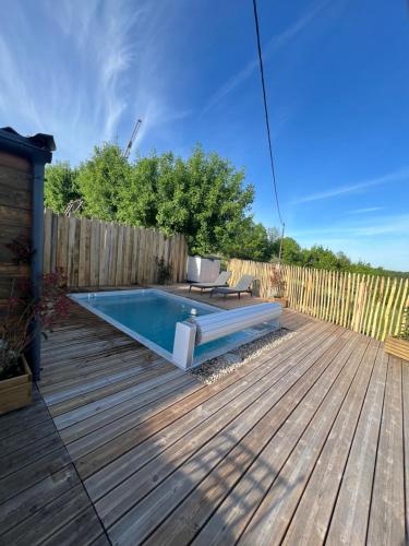 une terrasse avec une piscine et une clôture en bois dans l'établissement Chalet de Bonnat, à Salignac Eyvigues