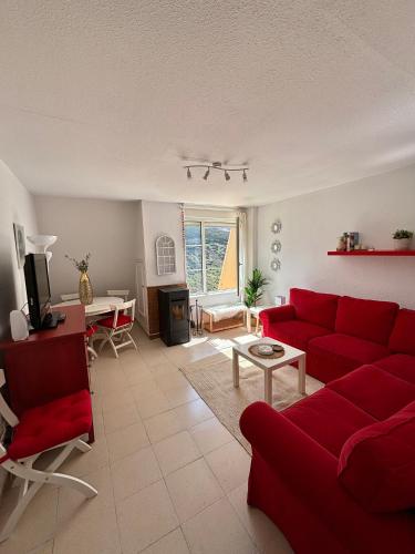 a living room with a red couch and a table at Apartamento en estación de esquí y montaña alto campoo in Brañavieja