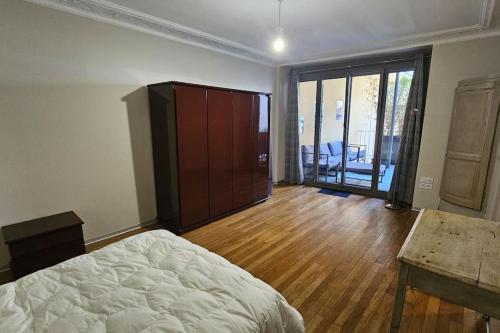 une chambre avec un lit, une commode et une table dans l'établissement Cœur de Ville au pied du funiculaire, à Thonon-les-Bains