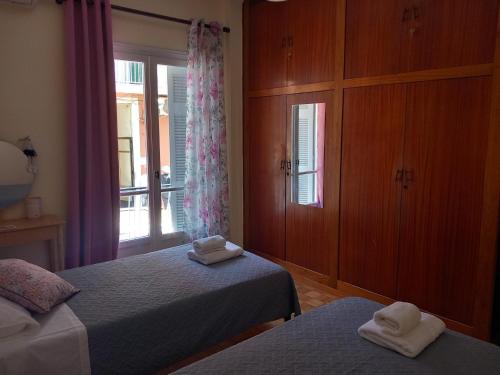 - une chambre avec 2 lits et une fenêtre dans l'établissement Spiros74 Apartment in the center of Corfu Town, à Corfou