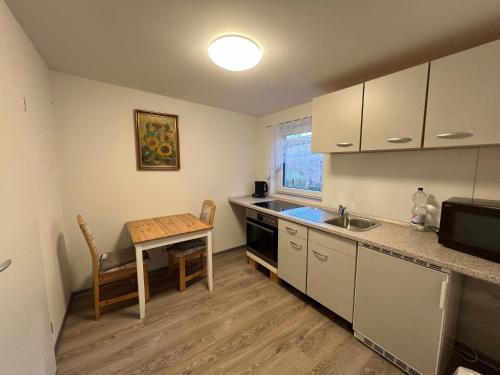 a kitchen with a table and a small table and a sink at Weesby Süderstraße 3.3 in Weesby