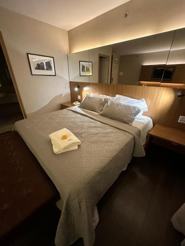 a bedroom with a bed with a white towel on it at Flat Radisson Blu São Paulo in Sao Paulo