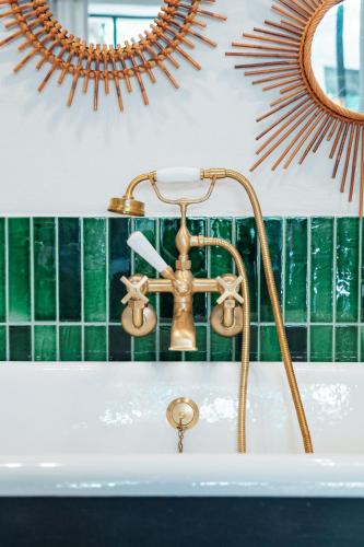 La salle de bains est pourvue d'un lavabo avec un robinet en laiton. dans l'établissement LA SUITE - Maison M Fabre, à Saint-Rémy-de-Provence