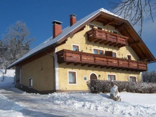 a house with a balcony on the side in the snow at Ferienwohnung für 9 Personen ca 110 qm in Bleiburg, Kärnten Unterkärnten in Bleiburg