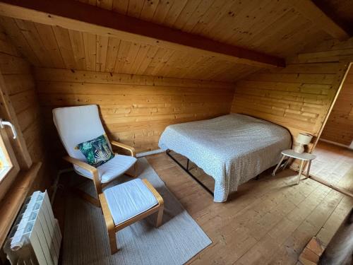Zimmer im Dachgeschoss mit einem Bett und einem Stuhl in der Unterkunft Le Chalet « au Fil de l’eau » 