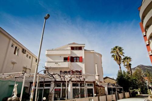 a white building with palm trees in front of it at Apartments Bonus in Budva