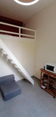 une chambre avec un escalier, un canapé et une table dans l'établissement Studio sur la Bièvre, à Bièvres