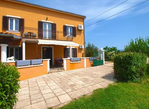 a yellow house with a balcony and a patio at Ferienwohnung für 6 Personen ca 75 qm in Valtura, Istrien Südküste von Istrien in Valtura