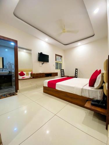 1 dormitorio con 1 cama, TV y bañera en The holy stay en Raipur