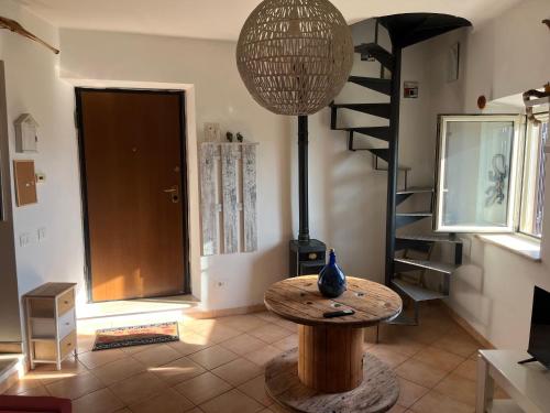 a room with a table and a spiral staircase at Tuscia Home Backpackers in Orte