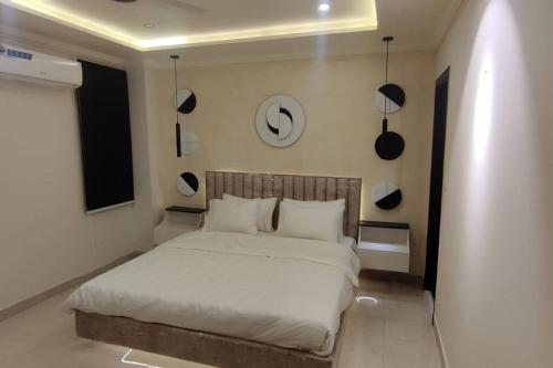 a bedroom with a bed with white sheets and pillows at Two Bedroom Designer Appartment in Rawalpindi