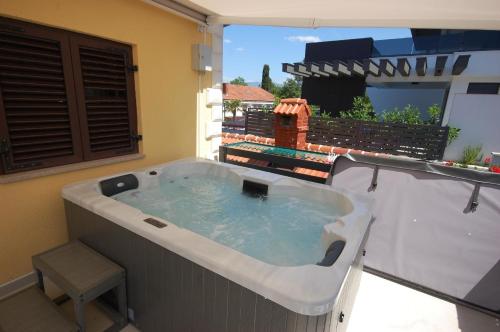 eine Whirlpool-Badewanne auf einer Terrasse mit Fenster in der Unterkunft Studio für 4 Personen ca 40 qm in Njivice, Kvarner Bucht Krk in Njivice