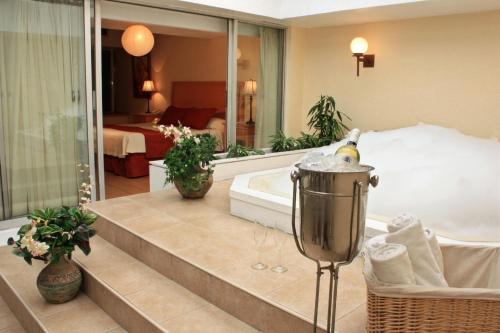 a hotel room with a tub and a bedroom at Hotel Villa Florida Córdoba in Córdoba