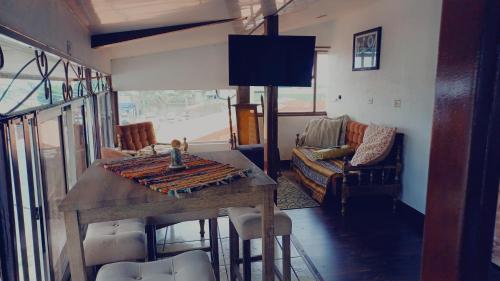un soggiorno con tavolo in legno e divano di La posada de nana a Alajuela