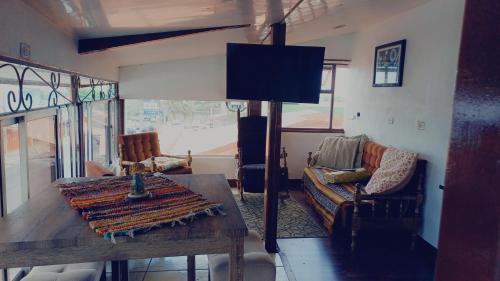 uma sala de estar com uma mesa e um sofá em La posada de nana em Alajuela