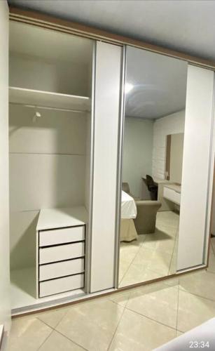 a mirror in a room with a bedroom and a bathroom at Casa aconchego in Feira de Santana