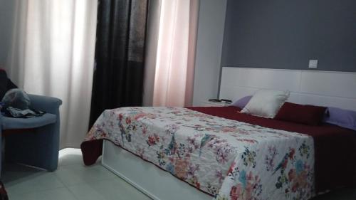 niewielka sypialnia z łóżkiem i krzesłem w obiekcie Casa Mrichica w mieście Mão para Trás