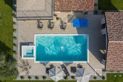 uma vista sobre uma piscina com cadeiras e uma piscina em Ferienhaus mit Privatpool für 7 Personen ca 200 qm in Loborika, Istrien Südküste von Istrien em Loborika