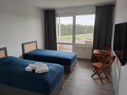 a hotel room with two beds and a window at BurgK59, 3 BR, 6 Beds, TV, Kitchen and Bath in Muldenstein