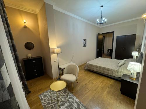 a bedroom with a bed and a chair and a table at Mtskheta apartment 17 in Mtskheta