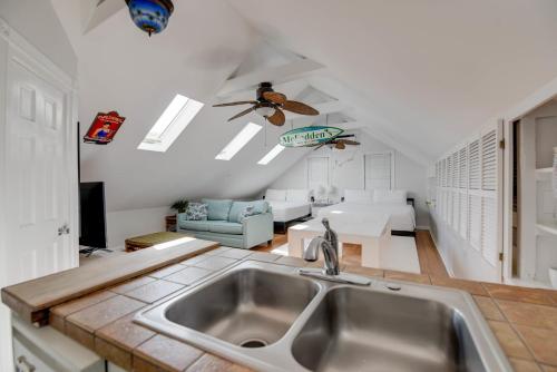 uma cozinha com um lavatório e uma sala de estar em Traveler's Palm by Brightwild em Key West