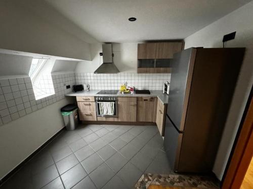 a small kitchen with a refrigerator and a sink at Altstadt-Glück - Terrasse&Sauna in Andernach