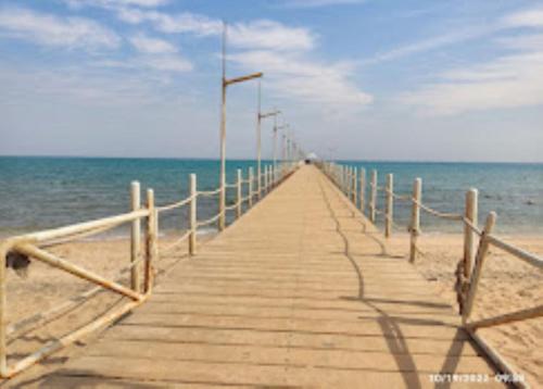 a wooden pier stretches out into the ocean at شاليه الهدوء والفخامة PORTO Studio in Al Ḩafāʼir