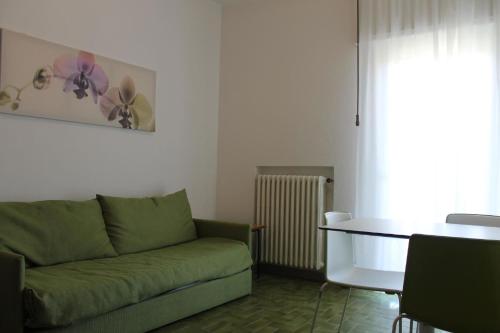 a living room with a green couch and a table at Ferienwohnung für 2 Personen 1 Kind ca 35 qm in Malcesine, Gardasee Ostufer Gardasee - a78215 in Malcesine