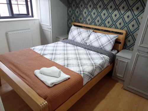 a small bedroom with a bed with two towels on it at SEVENOAKS in Bolton