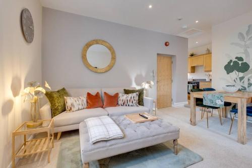 a living room with a couch and a table at Stylish Modern Town Centre Flat in Carterton