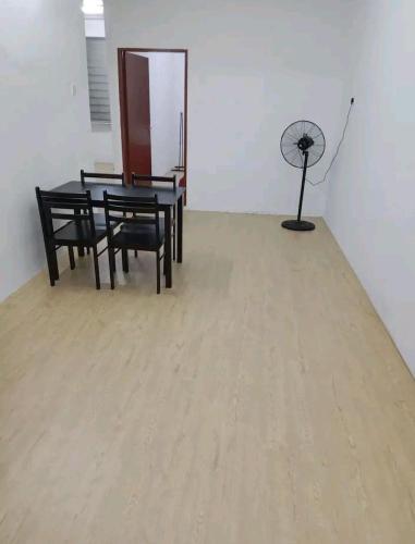 una sala da pranzo con tavolo, sedie e ventilatore di Bahau Taman Seri mutiara homestay a Bahau