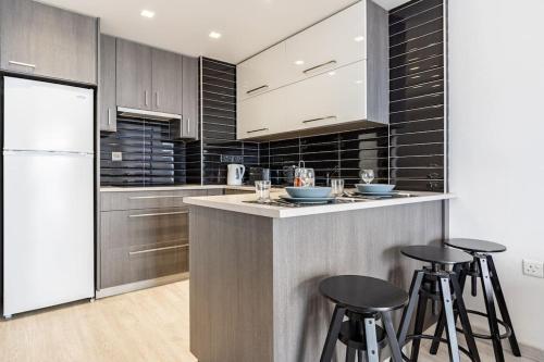 a kitchen with a counter with stools in it at Must Stay - Finikoudes Seaview in Larnaka
