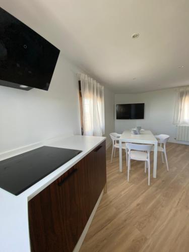 a kitchen and dining room with a table and chairs at EL RINCÓN DE DENVER in Suances