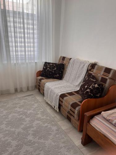 ein Wohnzimmer mit einem Sofa und einem Fenster in der Unterkunft casa buna 1 in Rădăuţi