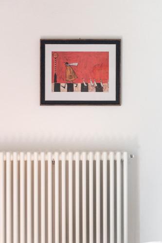 a picture hanging on a wall above a radiator at Bolgheri Countryhouse in Bolgheri