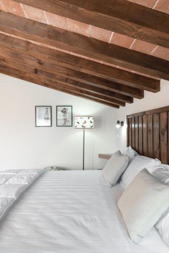 a bedroom with a large bed with white sheets and pillows at Bolgheri Countryhouse in Bolgheri