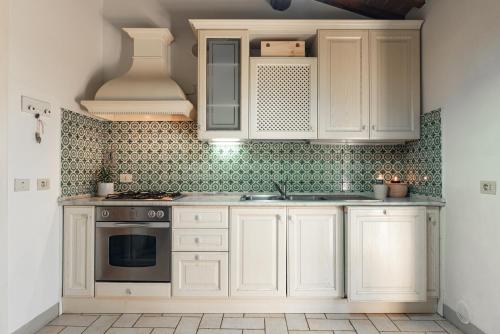 a kitchen with white cabinets and a stove at Bolgheri Countryhouse in Bolgheri