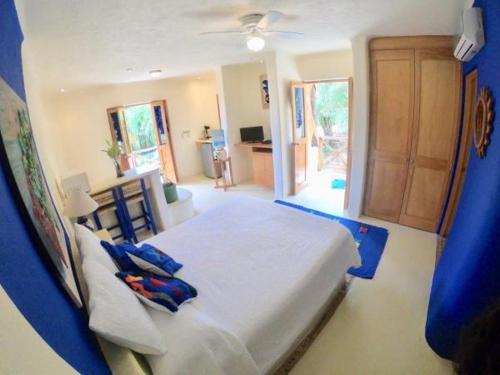 a bedroom with a large bed with blue pillows at Mar y Sueños Suites in Sayulita