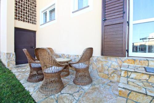 3 Korbstühle und ein Tisch vor einem Haus in der Unterkunft Studio für 4 Personen ca 48 qm in Fažana, Istrien Istrische Riviera in Fažana
