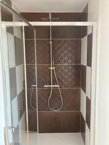 une douche avec une porte vitrée dans une salle de bain dans l'établissement Gîte au cœur de la Suisse Normande, à Clécy