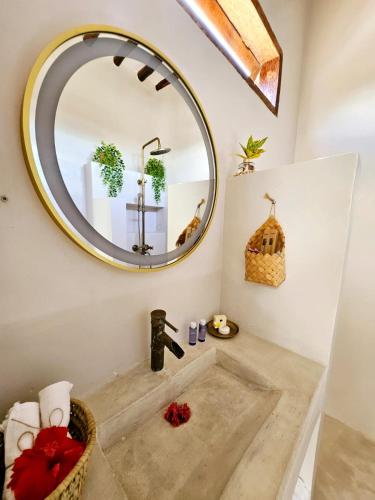 a bathroom with a mirror and a sink at Mfumbwi Twins Villa in Jambiani