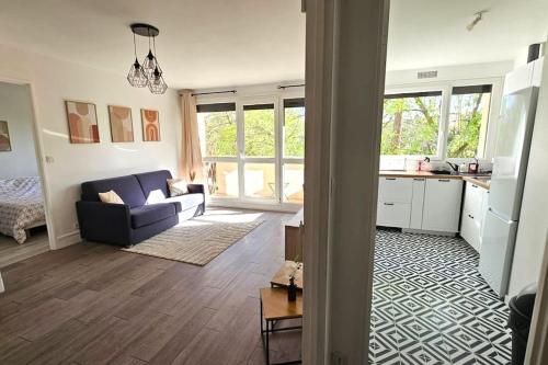 uma sala de estar com um sofá e uma cozinha em Agréable 2 pièces à Savigny sur Orge em Savigny-sur-Orge