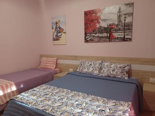 een slaapkamer met 2 bedden en een schilderij aan de muur bij Apartment Eclipse in Sarandë
