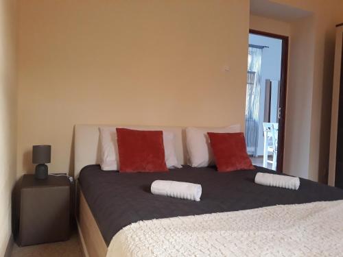 Un dormitorio con una cama con almohadas rojas y blancas. en Three Rivers Apartments - private free parking, self check-in, en Oradea